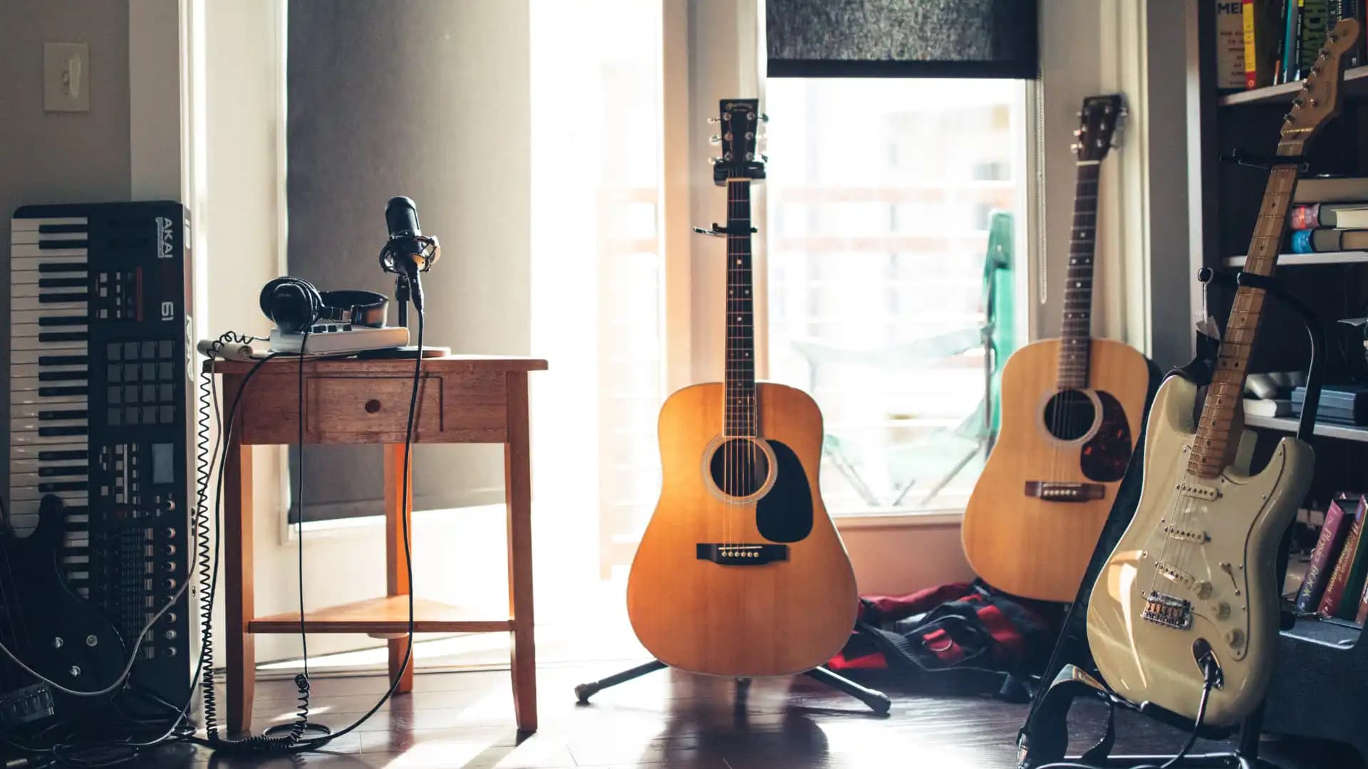 Room with a keyboard, several guitars, and a bass guitar.